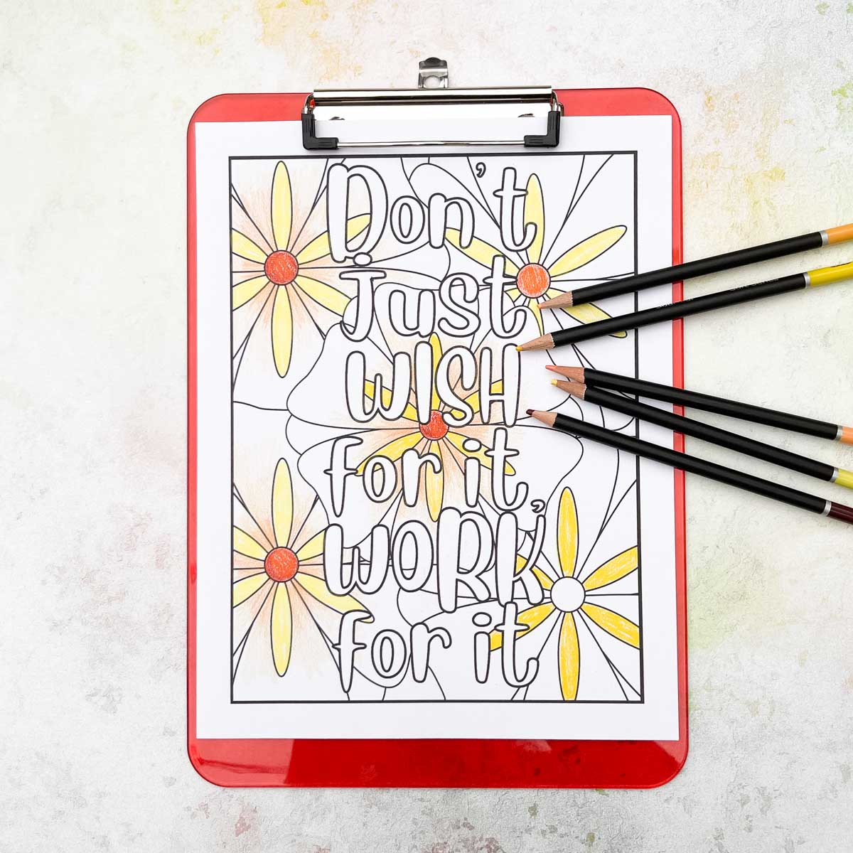 Quote coloring page on clipboard with colored pencils.
