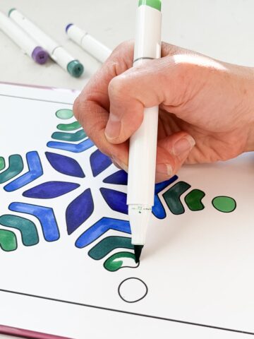 Coloring page being colored in with brush markers.