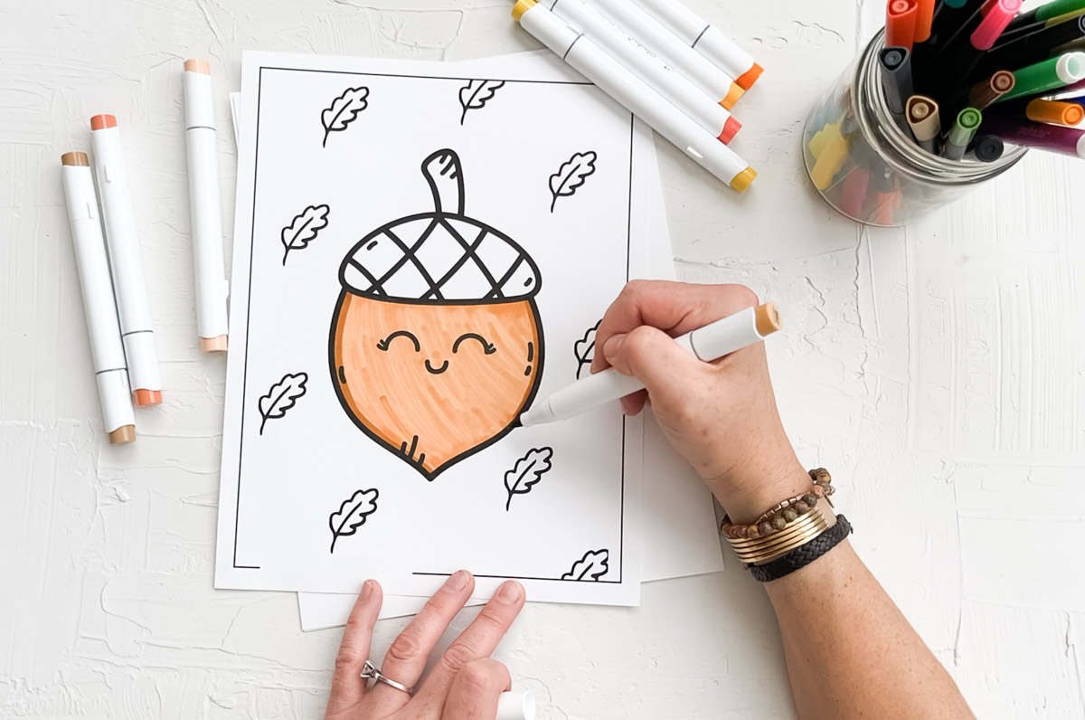 Free coloring page in PDF format featuring an acorn being colored by an adult.