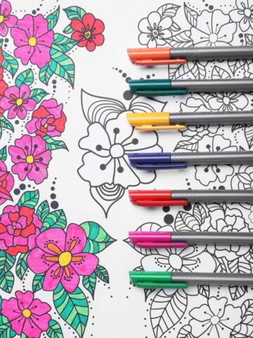 Partially complete floral coloring page with markers.